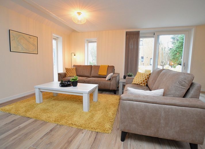 Ferienhaus De Nagtegaal 23 in De Dennen, Texel, umgeben von Natur mit einer sonnigen Terrasse.