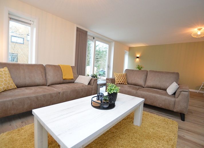 Ferienhaus De Nagtegaal 23 in De Dennen, Texel, umgeben von Natur mit einer sonnigen Terrasse.