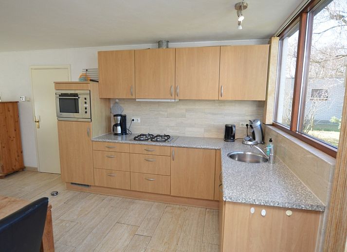 Gemuetliches Wohnzimmer des Ferienhauses de Parel 198 in De Dennen, Texel mit Blick auf den Garten.