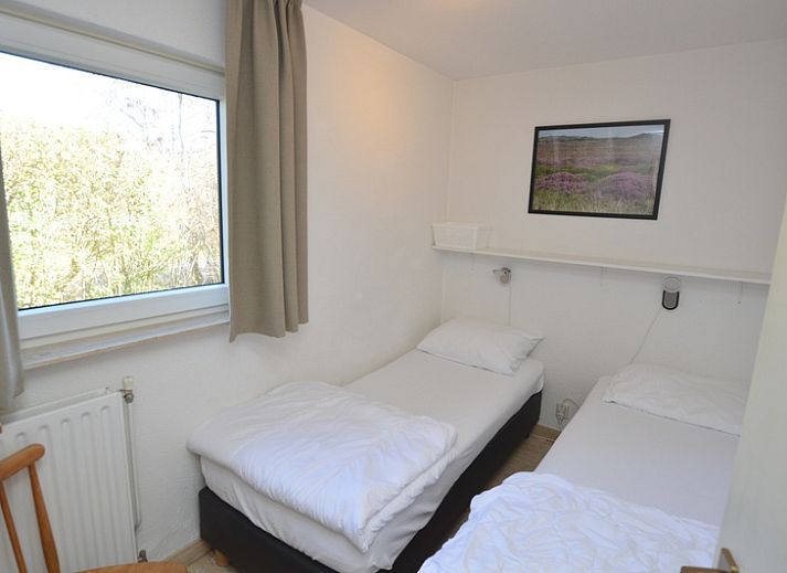 Gemuetliches Wohnzimmer des Ferienhauses de Parel 198 in De Dennen, Texel mit Blick auf den Garten.