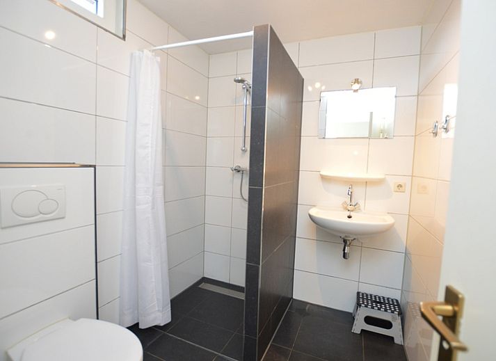 Gemuetliches Wohnzimmer des Ferienhauses de Parel 198 in De Dennen, Texel mit Blick auf den Garten.