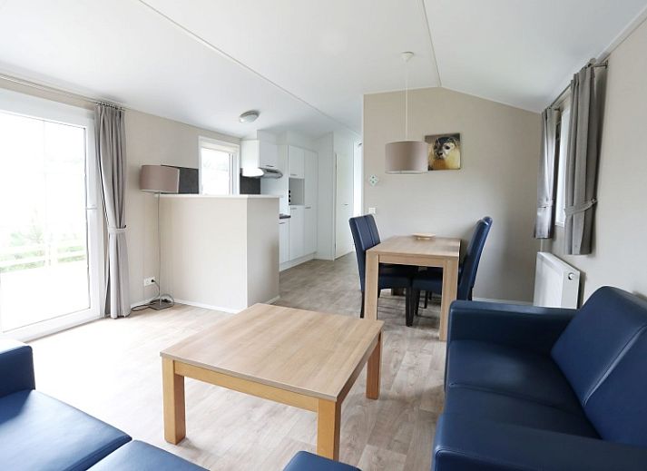 Helles Wohnzimmer von Villetta Sauna, Texel, mit bequemen Sofas und Blick auf die Natur.