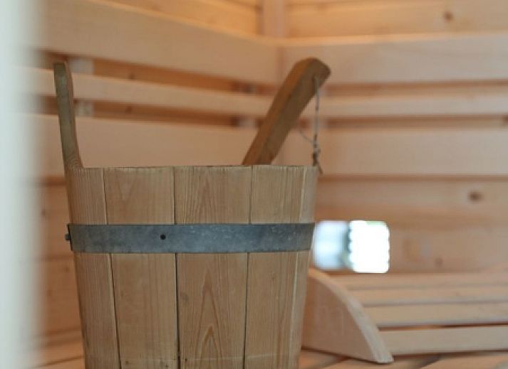 Helles Wohnzimmer von Villetta Sauna, Texel, mit bequemen Sofas und Blick auf die Natur.