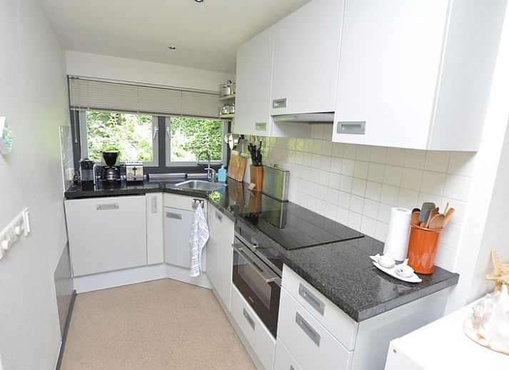 Lichte woonkamer van Vakantiehuis 't Hoogelandt 202 - Aan Zee in De Dennen, Texel met uitzicht op de groene tuin.