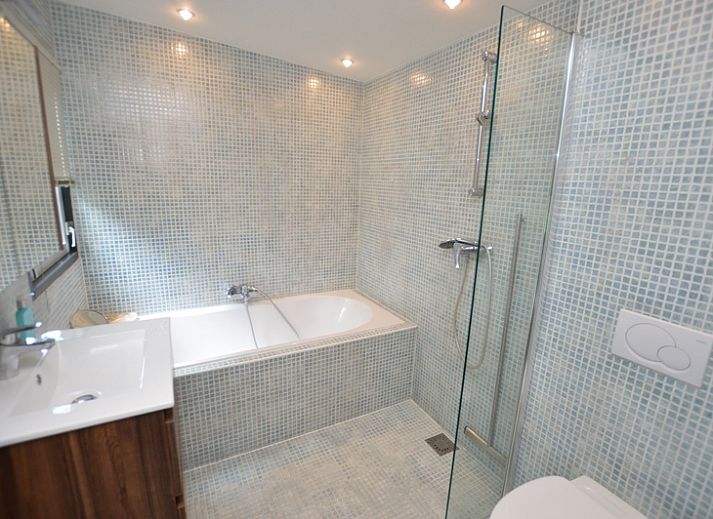 Lichte woonkamer van Vakantiehuis 't Hoogelandt 202 - Aan Zee in De Dennen, Texel met uitzicht op de groene tuin.