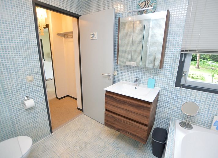 Lichte woonkamer van Vakantiehuis 't Hoogelandt 202 - Aan Zee in De Dennen, Texel met uitzicht op de groene tuin.