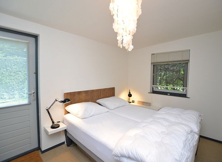 Lichte woonkamer van Vakantiehuis 't Hoogelandt 202 - Aan Zee in De Dennen, Texel met uitzicht op de groene tuin.