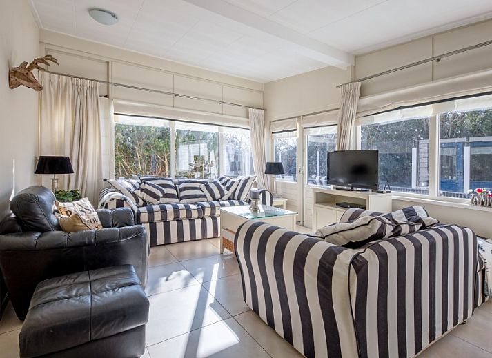 Gemuetliches Wohnzimmer im Bungalowpark 't Hoogelandt, De Dennen, Texel mit bequemen Sitzgelegenheiten und viel Licht.