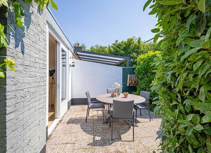 Die sonnige Terrasse des Ferienhauses Bungalowpark 't Luwe Land - 7B - De Wijnhof in De Dennen, Texel, ist ideal fuer Mahlzeiten im Freien.