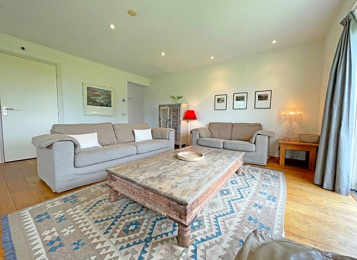 Gezellige woonkamer van Appartement Bos en Duin 40 in De Dennen, Texel met comfortabele banken en uitzicht op de natuur.