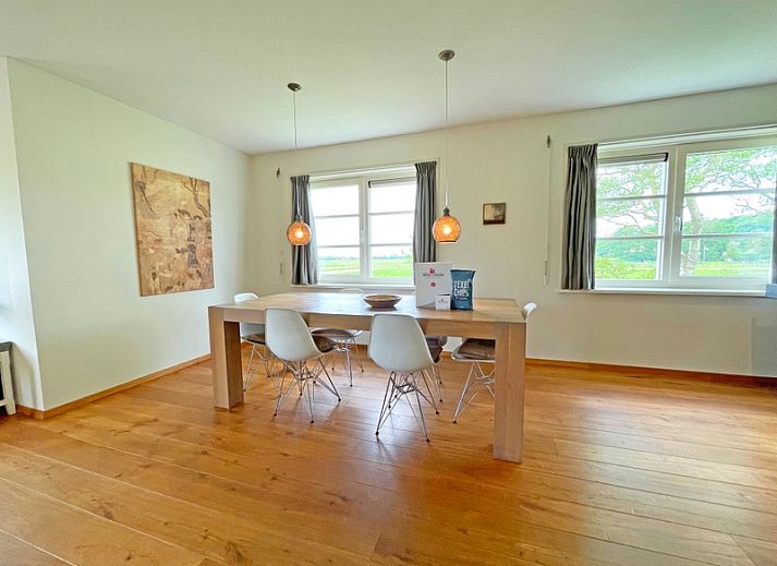 Gezellige woonkamer van Appartement Bos en Duin 40 in De Dennen, Texel met comfortabele banken en uitzicht op de natuur.