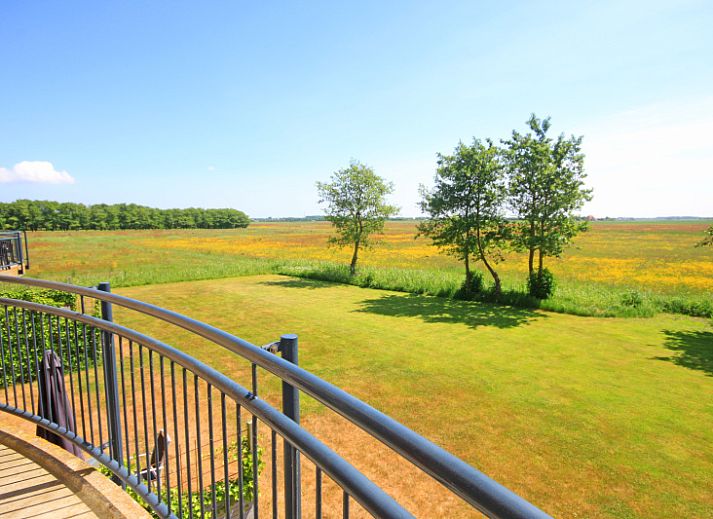 Ruime woonkamer van Appartement Bos en Duin 40, Texel, met rustieke houten tafel en sfeervolle verlichting.