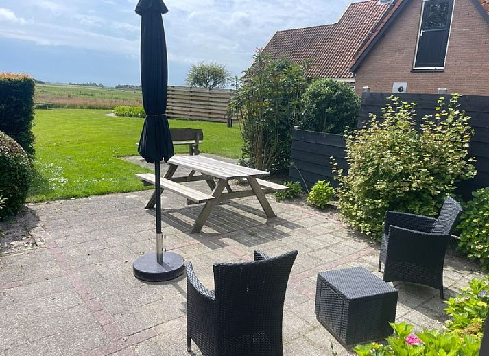 Exterior of vacation home Wollewei in De Dennen, Texel, surrounded by green nature.