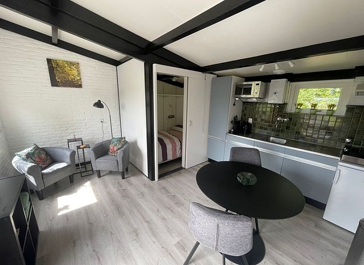 Terrace of Wollewei vacation home in De Dennen, Texel, with wooden picnic table and chairs.