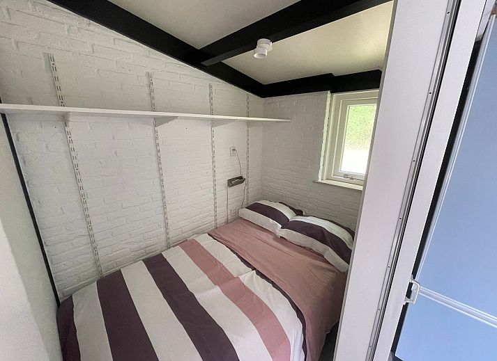 Terrace of Wollewei vacation home in De Dennen, Texel, with wooden picnic table and chairs.