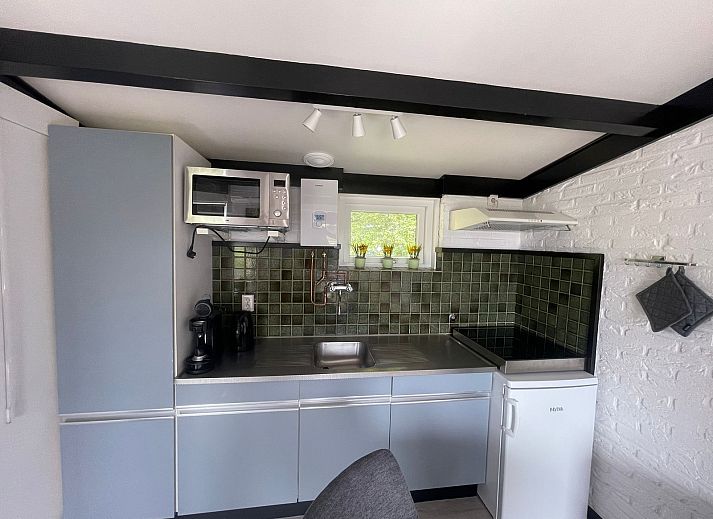 Terrace of Wollewei vacation home in De Dennen, Texel, with wooden picnic table and chairs.