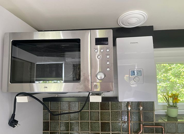 Terrace of Wollewei vacation home in De Dennen, Texel, with wooden picnic table and chairs.
