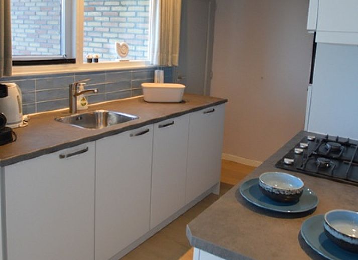 Gemuetliches Wohnzimmer im Bungalow Uterste Coogh 104, De Dennen, Texel, mit bequemer Sitzecke.