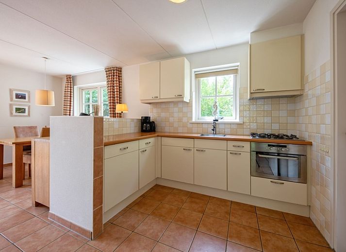 Rustikaler Charme von 't Mienthuis - De Prins, Ferienhaus in De Dennen, Texel, mit bunten Blumen und gruener Umgebung.