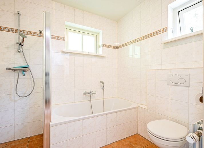 Rustikaler Charme von 't Mienthuis - De Prins, Ferienhaus in De Dennen, Texel, mit bunten Blumen und gruener Umgebung.