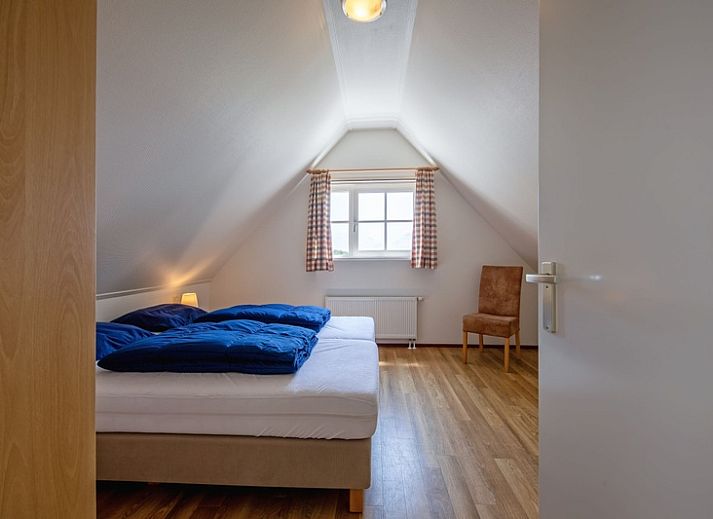 Rustikaler Charme von 't Mienthuis - De Prins, Ferienhaus in De Dennen, Texel, mit bunten Blumen und gruener Umgebung.