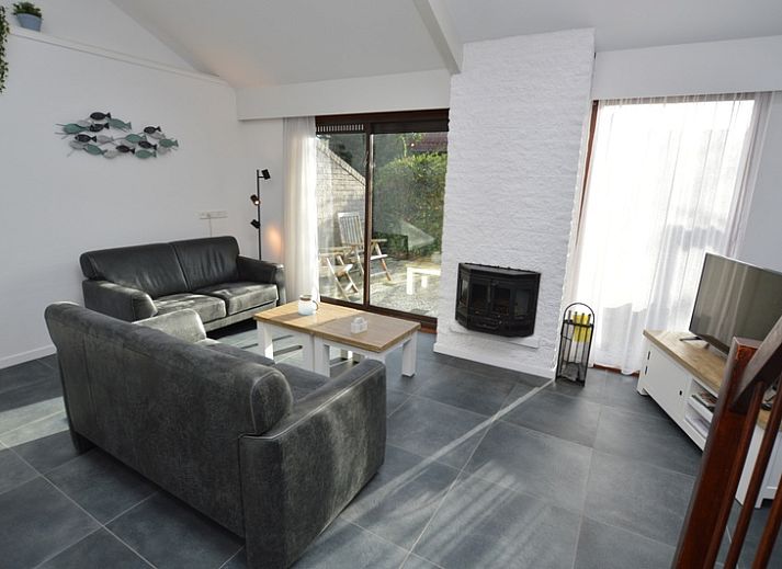 Gezellige woonkamer in Bungalowpark Gortersmient vakantiehuis Gortersmient 240, De Dennen, Texel, met uitzicht op de tuin.