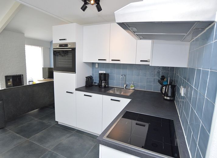 Gezellige woonkamer in Bungalowpark Gortersmient vakantiehuis Gortersmient 240, De Dennen, Texel, met uitzicht op de tuin.