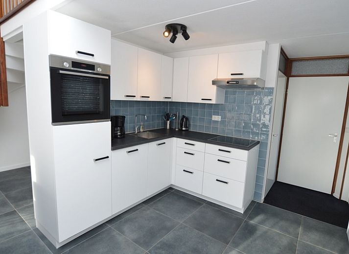 Gezellige woonkamer in Bungalowpark Gortersmient vakantiehuis Gortersmient 240, De Dennen, Texel, met uitzicht op de tuin.