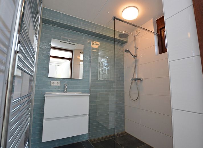 Gezellige woonkamer in Bungalowpark Gortersmient vakantiehuis Gortersmient 240, De Dennen, Texel, met uitzicht op de tuin.