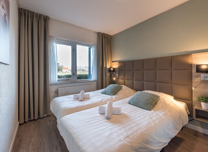 Cozy sitting area in Apartment Bos en Duin 12, Texel, with comfortable sofa and garden view.