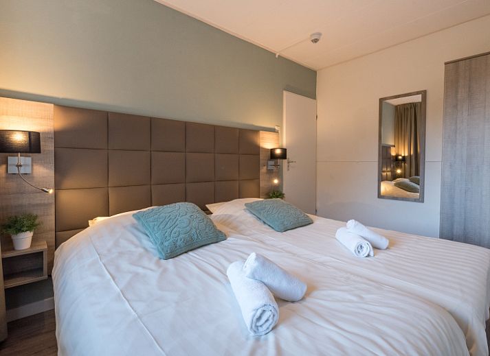 Cozy sitting area in Apartment Bos en Duin 12, Texel, with comfortable sofa and garden view.