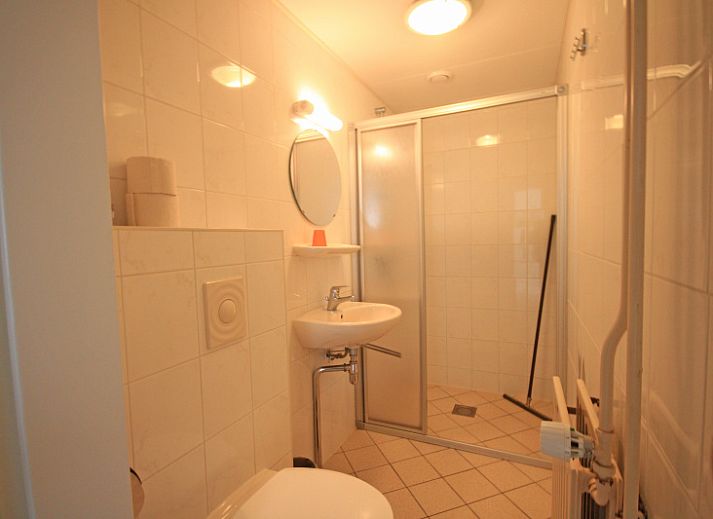 Cozy sitting area in Apartment Bos en Duin 12, Texel, with comfortable sofa and garden view.