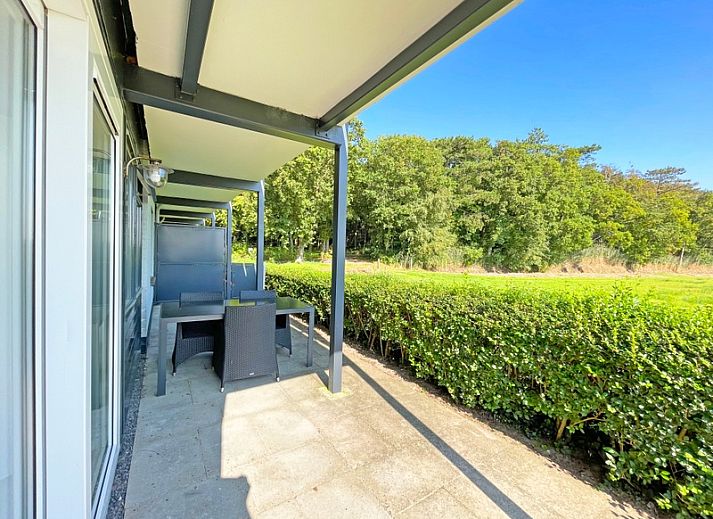 Cozy sitting area in Apartment Bos en Duin 12, Texel, with comfortable sofa and garden view.