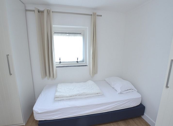 Gemuetliches Wohnzimmer des Ferienhauses de Parel 282, De Dennen, Texel, mit Blick auf den gruenen Garten.