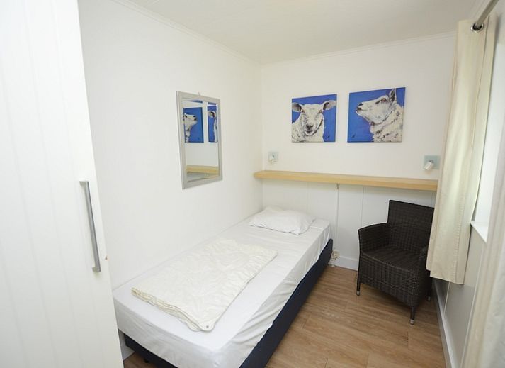 Helle Innenraeume im Ferienhaus de Parel 282, De Dennen, Texel mit gemuetlicher Sitzecke und Gartenblick.