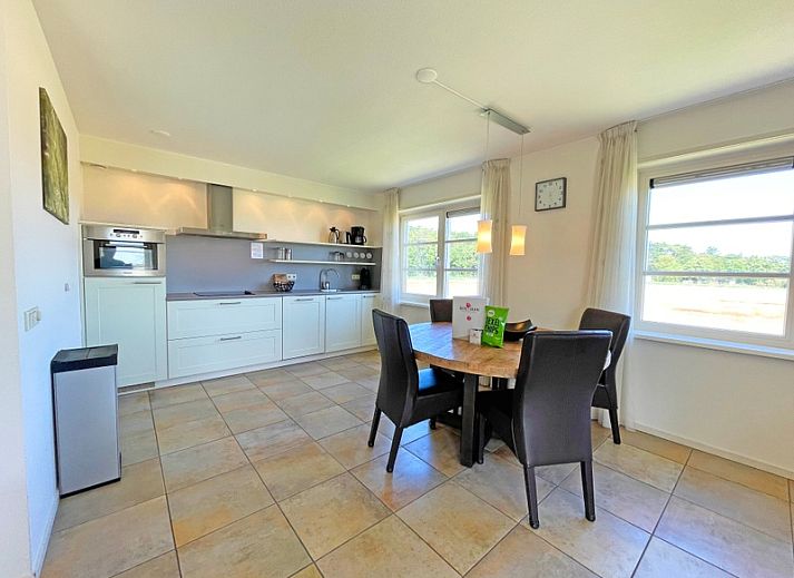 Gezellige zithoek in Appartement Bos en Duin 43, De Dennen, Texel met uitzicht op de groene omgeving.