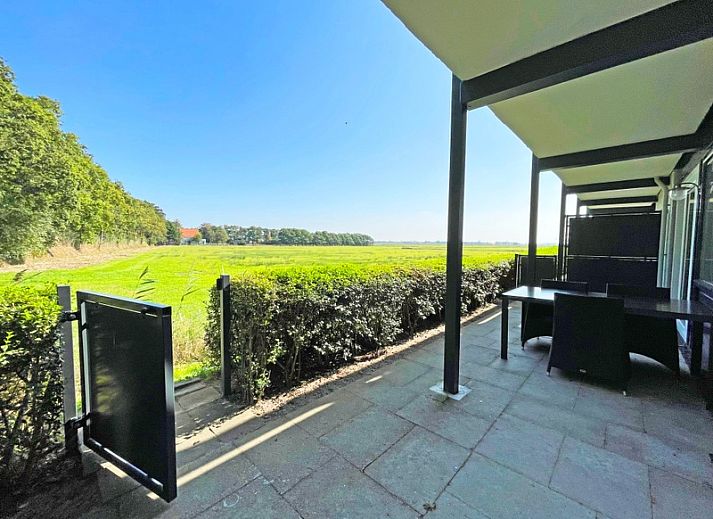 Bright and spacious living room of Apartment Bos en Duin 14, De Dennen, Texel with a view of nature.