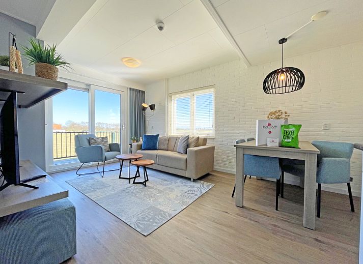 Lichte woonkamer van Appartement Bos en Duin 30 in De Dennen, Texel met comfortabele zithoek en uitzicht op de natuur.
