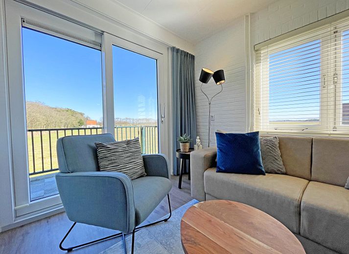 Lichte woonkamer van Appartement Bos en Duin 30 in De Dennen, Texel met comfortabele zithoek en uitzicht op de natuur.