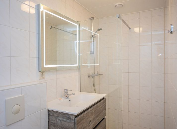 Stijlvolle woonkamer van Appartement Bos en Duin 30, De Dennen, Texel met uitzicht op het groene landschap.