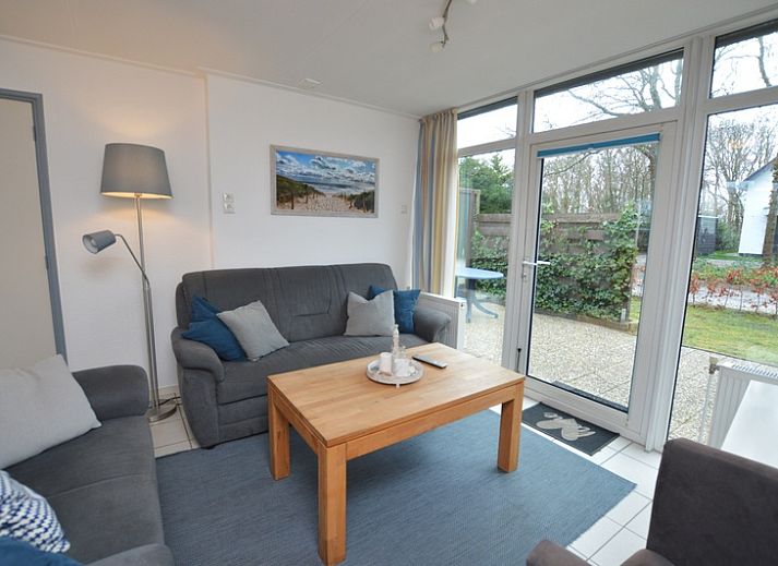 Ferienhaus de Parel 194 in De Dennen, Texel mit sonniger Terrasse und gruener Umgebung.