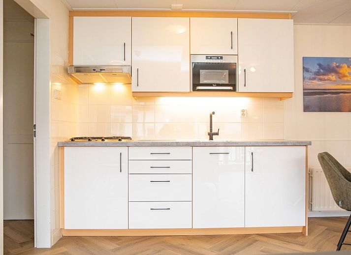 Stijlvolle zithoek in Appartement Bos en Duin 28, De Dennen, Texel, met moderne inrichting en veel natuurlijk licht.