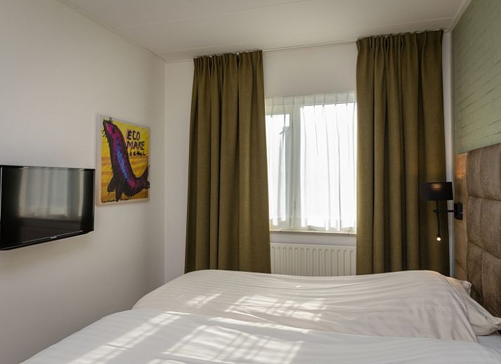 Stijlvolle zithoek in Appartement Bos en Duin 28, De Dennen, Texel, met moderne inrichting en veel natuurlijk licht.