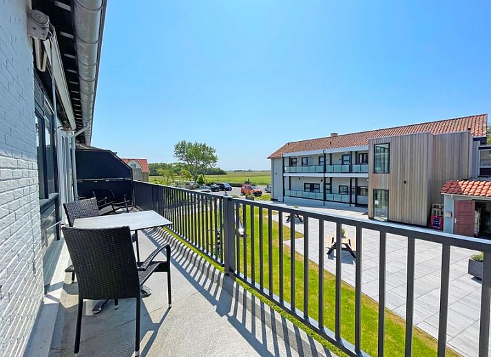 Ruime woonkamer van Appartement Bos en Duin 28, Texel, met flatscreen-tv en toegang tot het balkon voor een fris uitzicht.