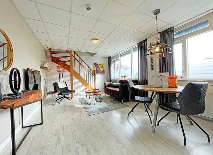 Gemuetliches Wohnzimmer im Appartement Bos en Duin 25, De Dennen, Texel mit Holztreppe und grosser Sitzecke.