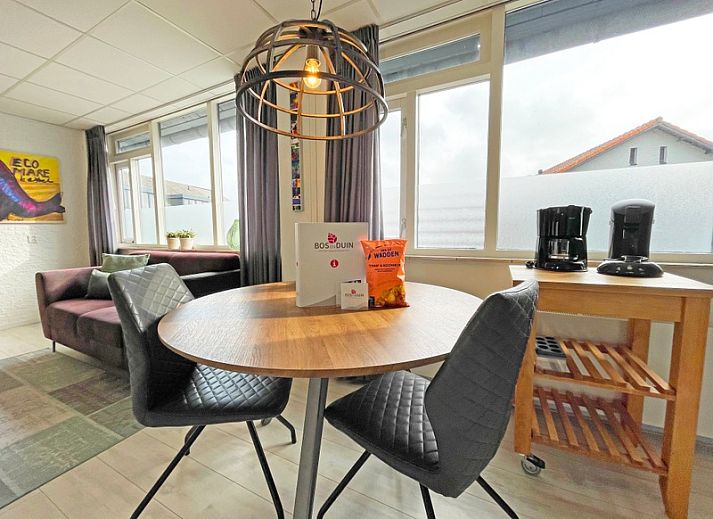 Gemuetliches Wohnzimmer im Appartement Bos en Duin 25, De Dennen, Texel mit Holztreppe und grosser Sitzecke.