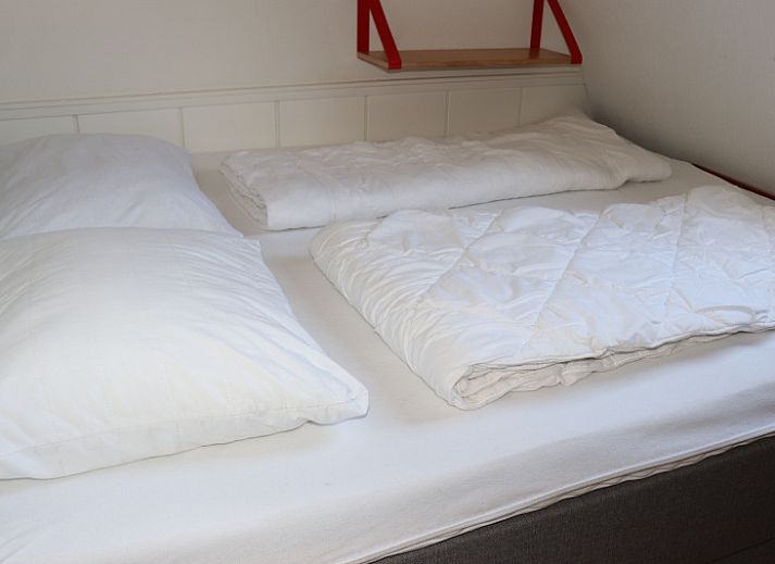 Gemuetliches Wohnzimmer im Ferienhaus Gortersmient 246, De Dennen, Texel. Komfortable Sitzecke mit Kamin fuer gemuetliche Abende.