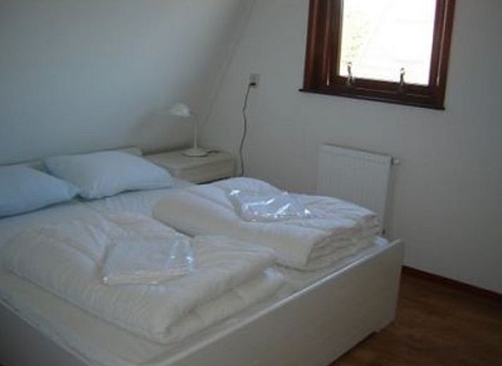 Gemuetliche Terrasse am Ferienhaus Gortersmient 338 in De Dennen, Texel, mit bequemen Stuehlen zum Entspannen.