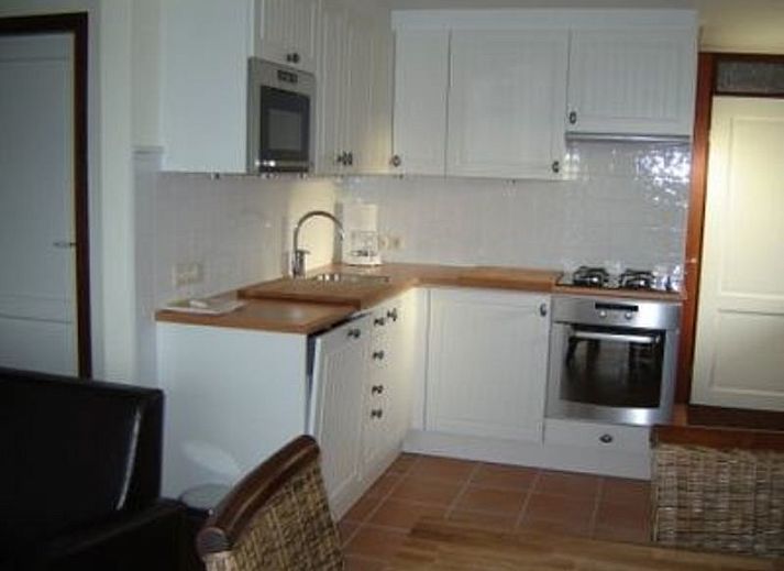 Gemuetliche Terrasse am Ferienhaus Gortersmient 338 in De Dennen, Texel, mit bequemen Stuehlen zum Entspannen.