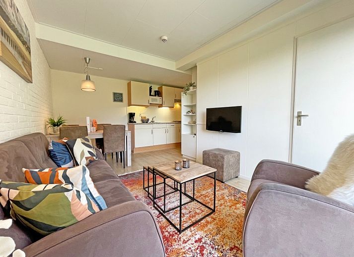 Gemuetliches Wohnzimmer des Appartements Bos en Duin 31 in De Dennen, Texel mit bequemer Sitzecke und Blick auf die Natur.
